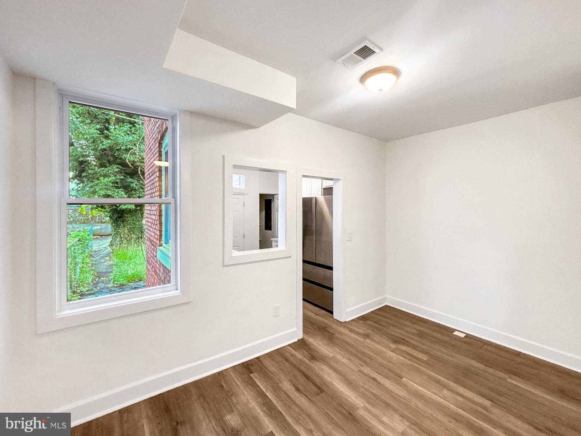 2217 Riggs Avenue Baltimore, MD 21216 - Photo 4 of 26 a view of empty room with wooden floor and fan