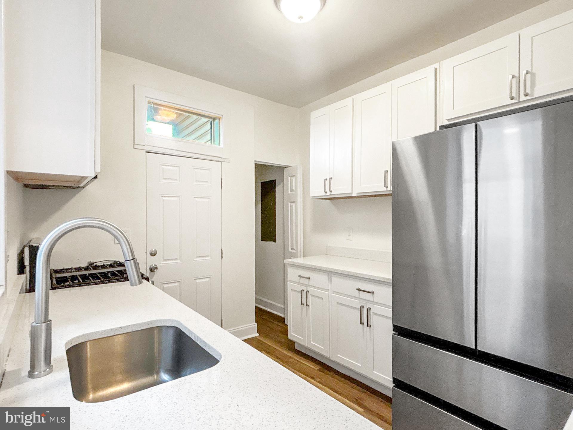 2217 Riggs Avenue Baltimore, MD 21216 - Photo 6 of 26 a kitchen with a refrigerator sink and white cabinets