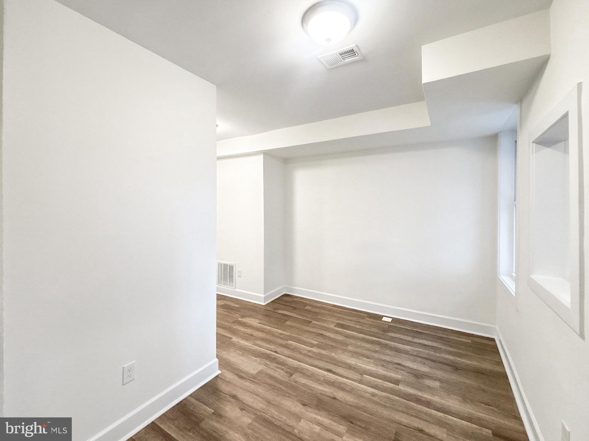 2217 Riggs Avenue Baltimore, MD 21216 - Photo 9 of 26 an empty room with wooden floor