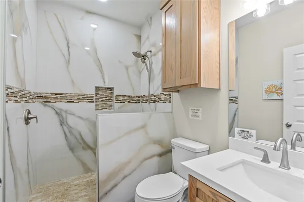 a bathroom with a sink a toilet and a mirror