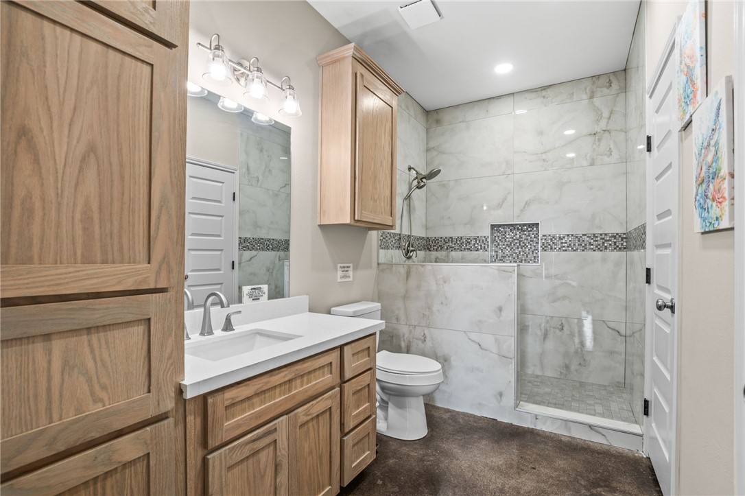 1263 East 2360th Circle Riviera, TX 78379 - Photo 22 of 40 a bathroom with a double vanity sink toilet and shower