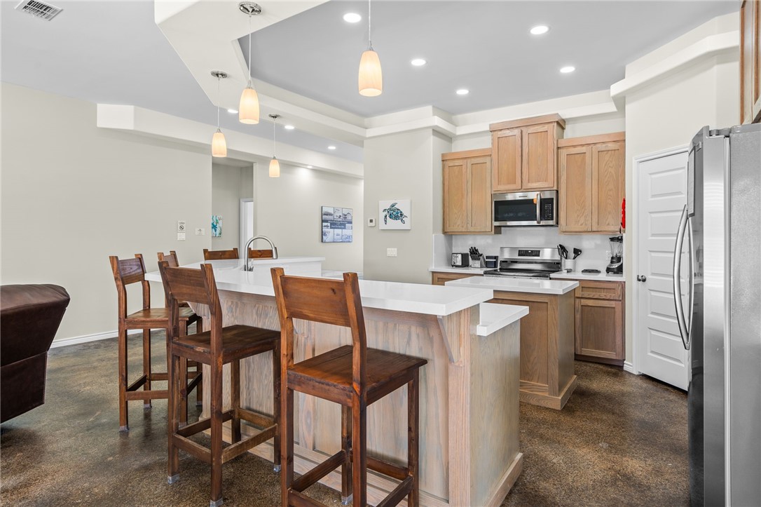 1263 East 2360th Circle Riviera, TX 78379 - Photo 5 of 40 a kitchen that has a lot of cabinets in it with stainless steel appliances a dining table and chairs