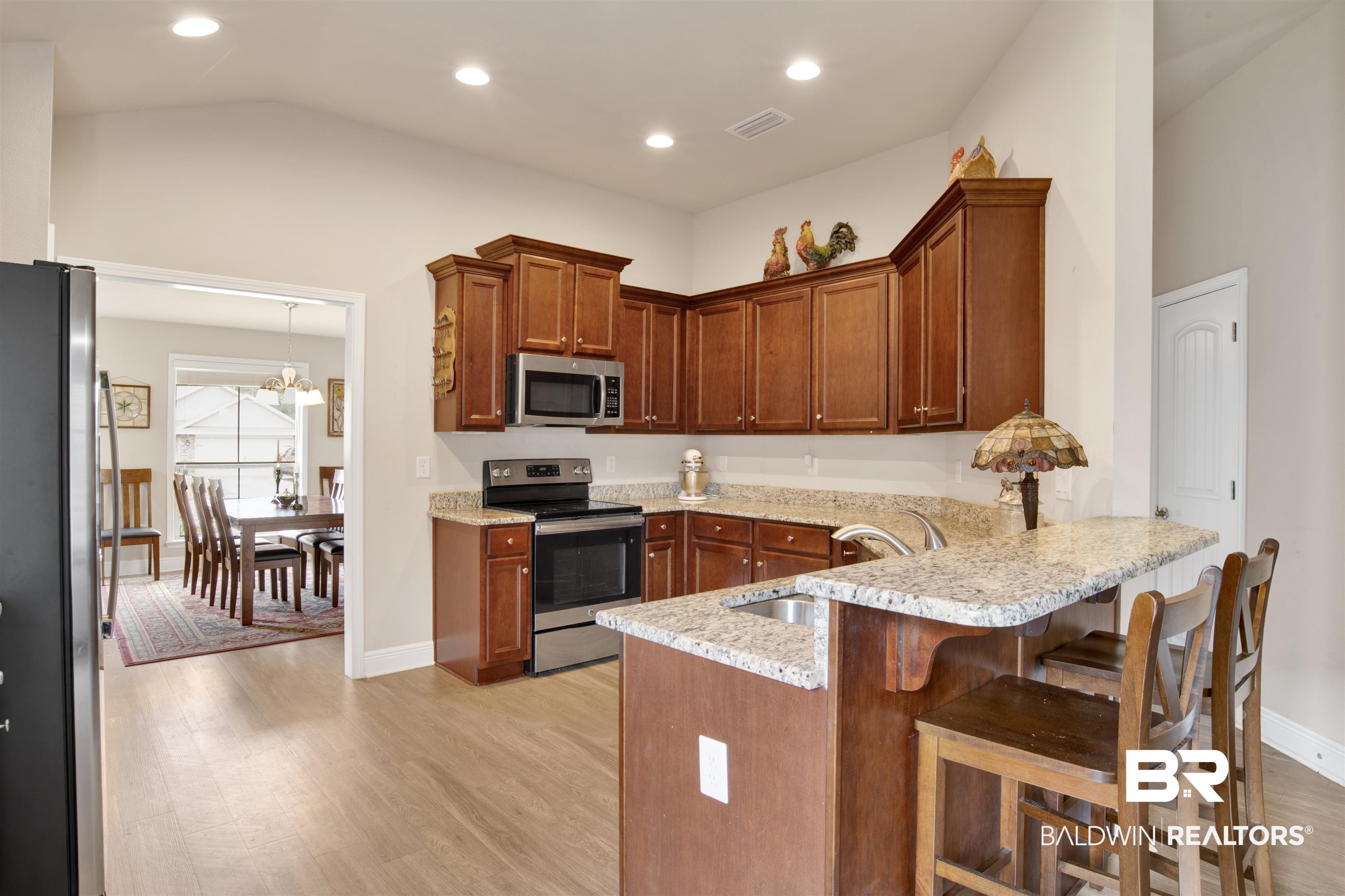 22056 Garland Loop Silverhill, AL 36576 - Photo 6 of 28 Kitchen featuring a sink, appliances with stainless steel finishes, a peninsula, light wood-style flooring, and visible vents