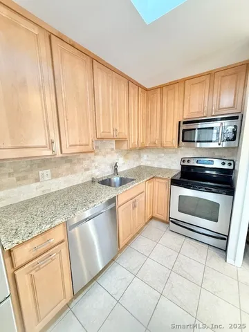 a kitchen with granite countertop white cabinets and appliances