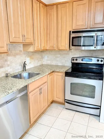 a kitchen with granite countertop white cabinets and appliances