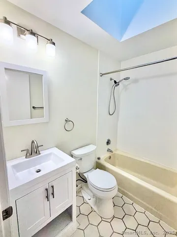 a bathroom with a double vanity sink toilet mirror and shower