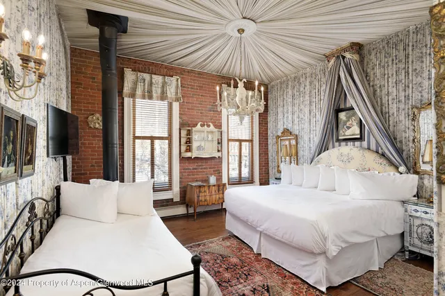 a bedroom with a bed and a chandelier