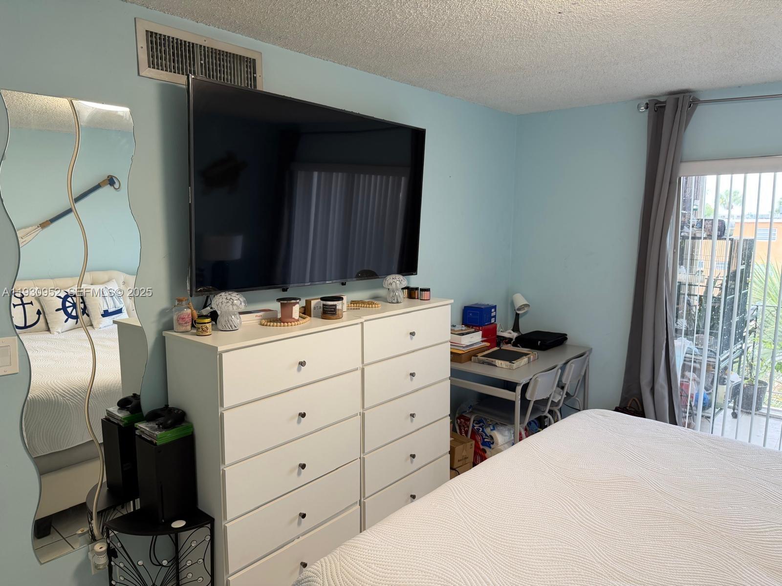1255 West 53rd Street, Unit 301 Hialeah, FL 33012 - Photo 7 of 9 a room with a bed and a chair in it