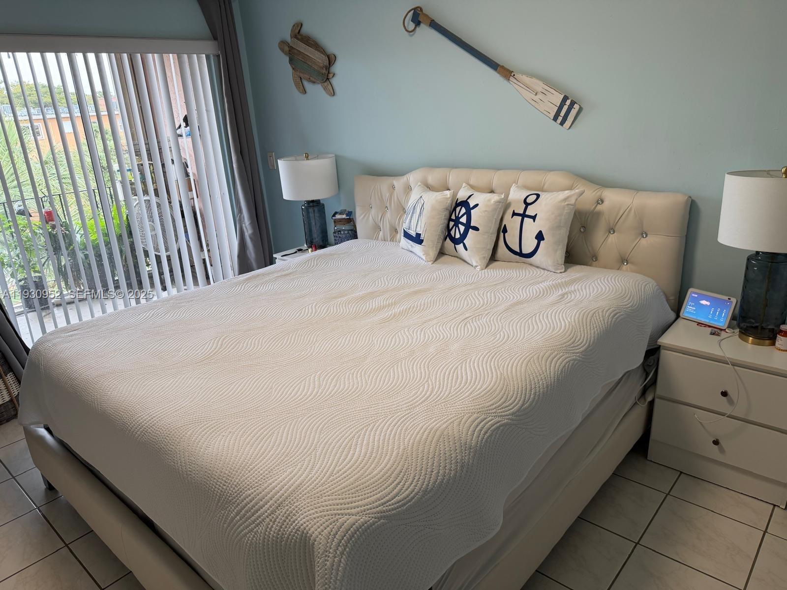 1255 West 53rd Street, Unit 301 Hialeah, FL 33012 - Photo 8 of 9 a bed sitting in a bedroom next to a lamp