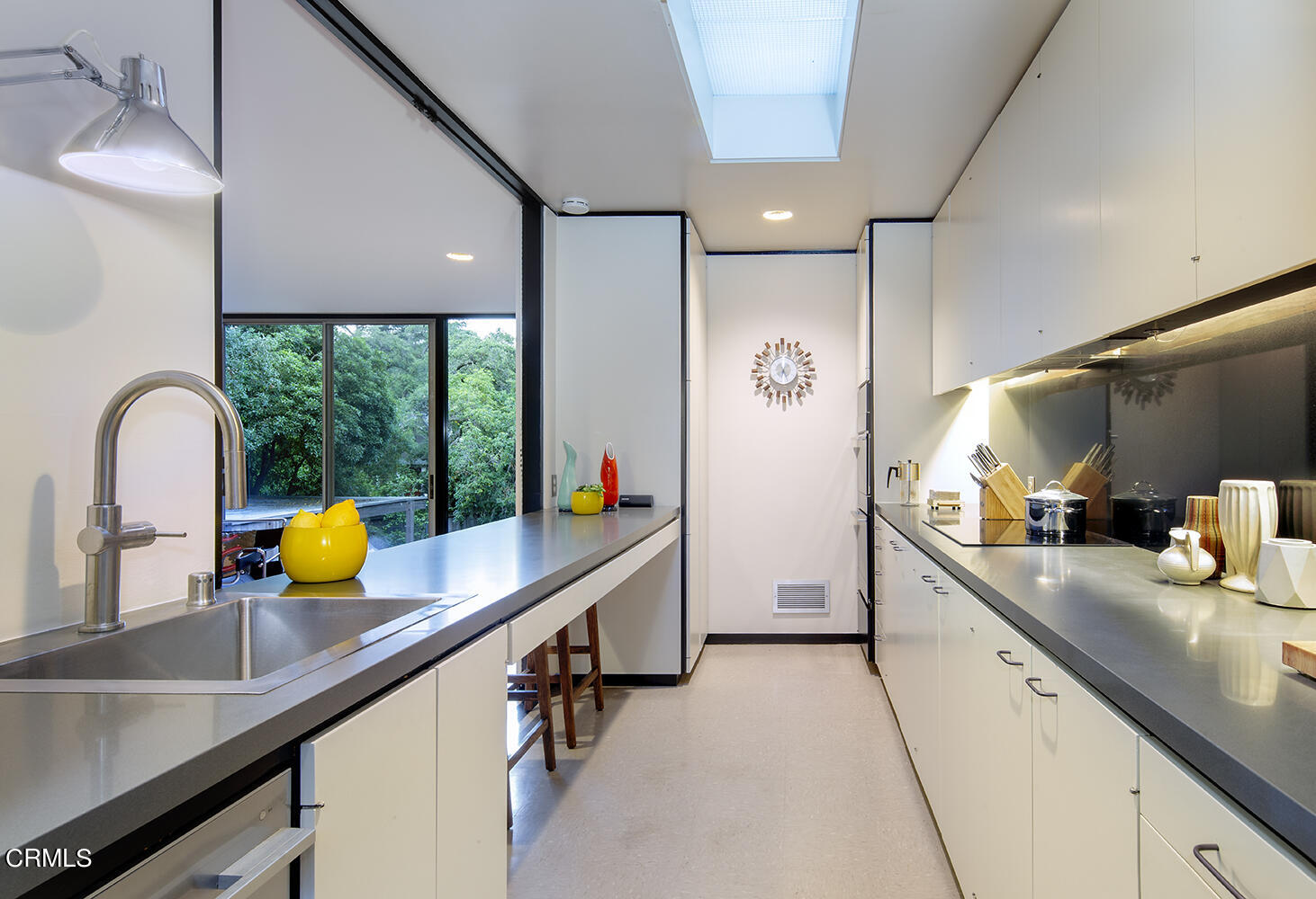 215 La Vereda Road Pasadena, CA 91105 - Photo 9 of 21 a kitchen with blue lights sink and chairs