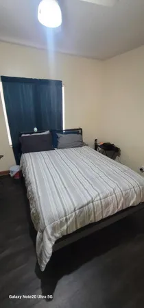 a bed sitting in a bedroom next to a cabinet