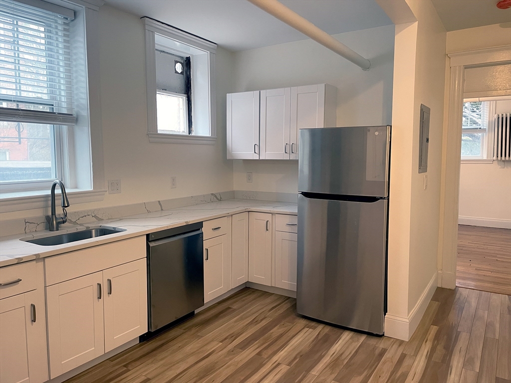 15 Thatcher Street, Unit B Brookline, MA 02446 - Photo 2 of 8 a kitchen with a refrigerator sink and cabinets