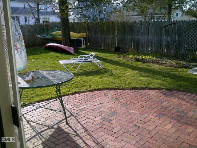 148 Catherine Street Fairfield, CT 06824 - Photo 11 of 25 a view of a backyard with table and chairs potted plants and wooden fence