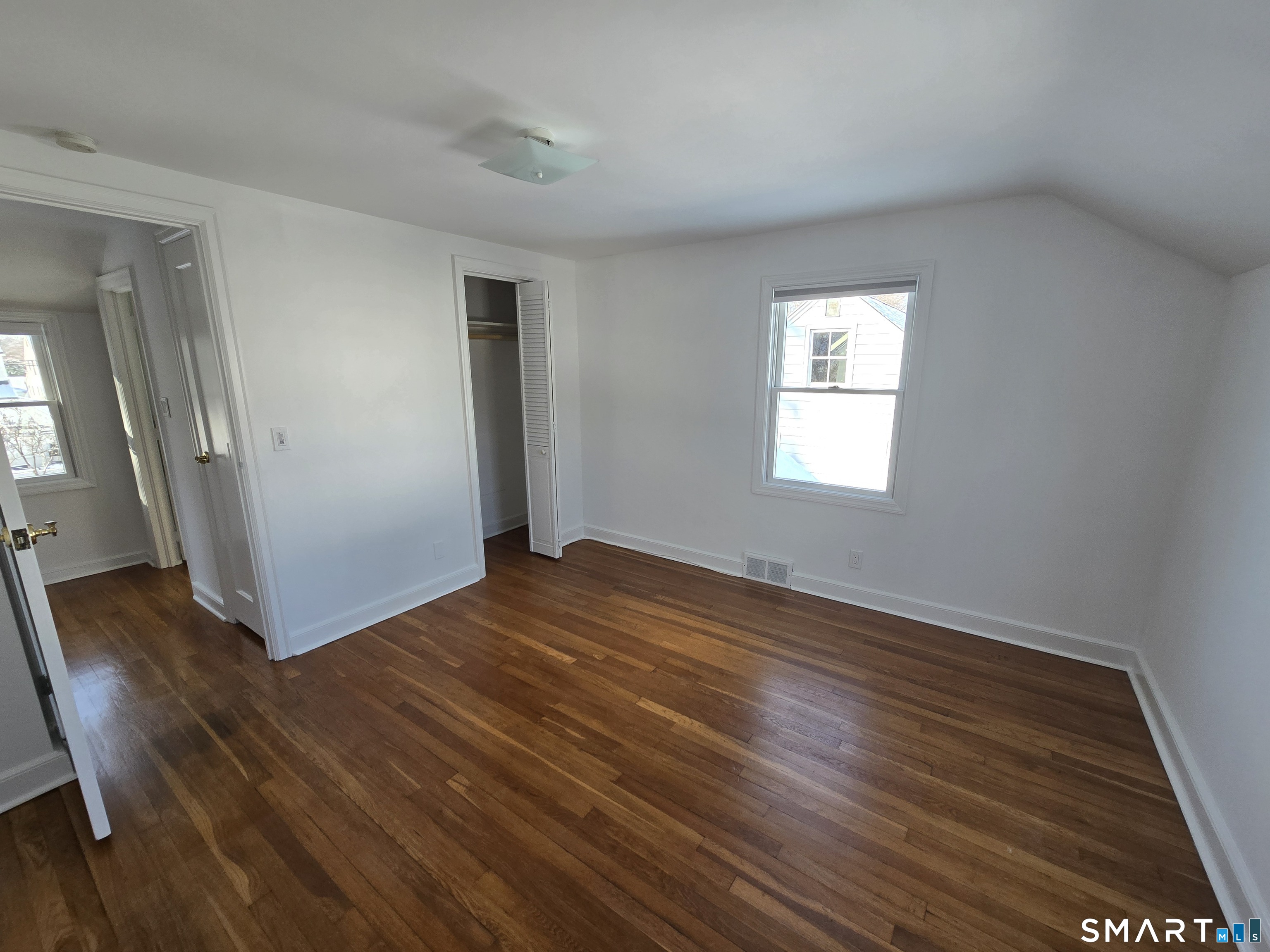 148 Catherine Street Fairfield, CT 06824 - Photo 24 of 25 an empty room with wooden floor and windows