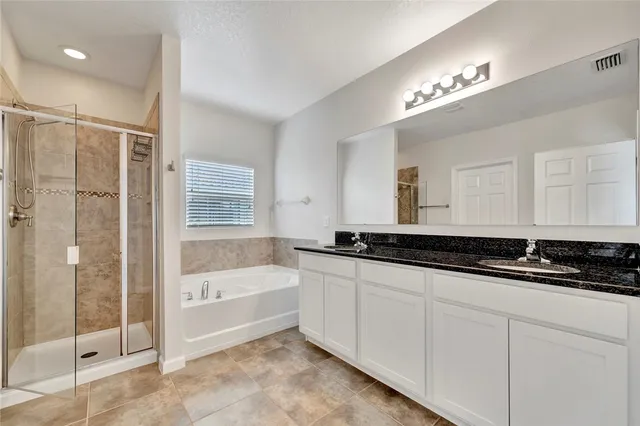 a spacious bathroom with a granite countertop sink a toilet a mirror and shower