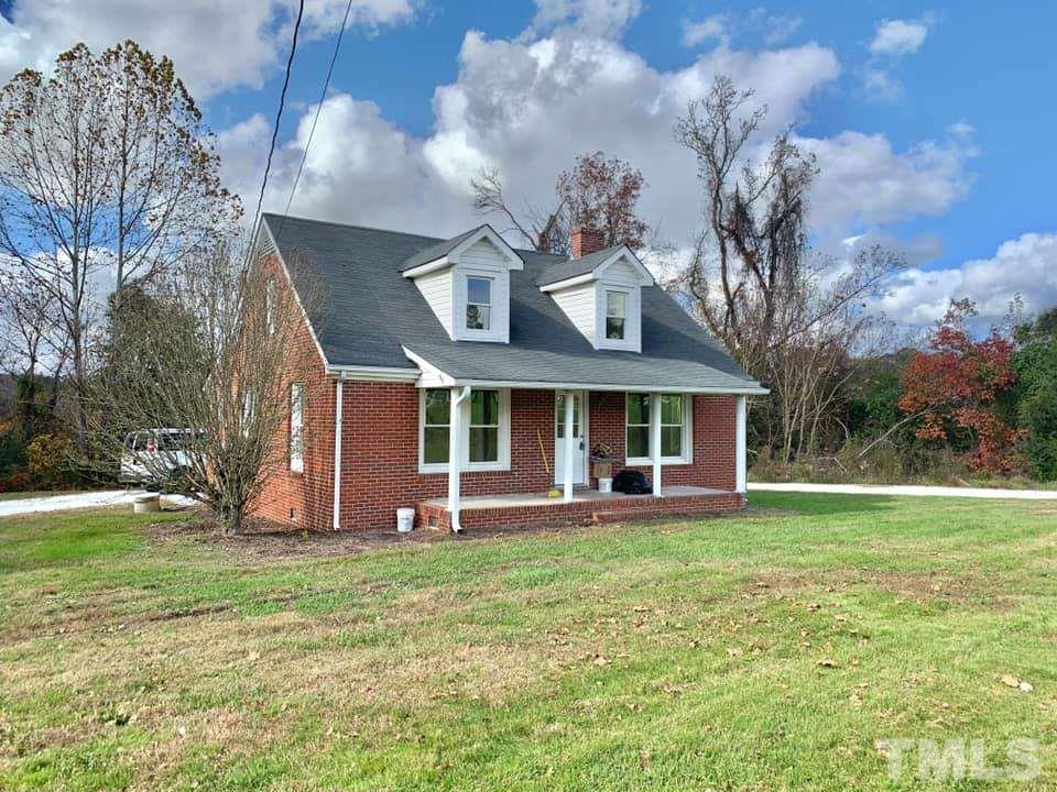 71 Gentry Dunkley Road Roxboro, NC 27574 - Photo 1 of 14 a front view of a house with a garden and trees