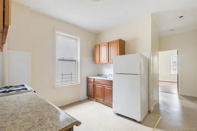 a kitchen with a refrigerator a stove top oven and cabinets