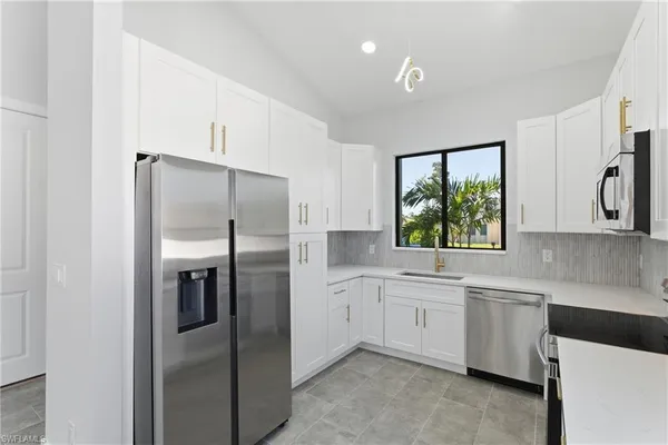 a kitchen with a refrigerator sink and cabinets