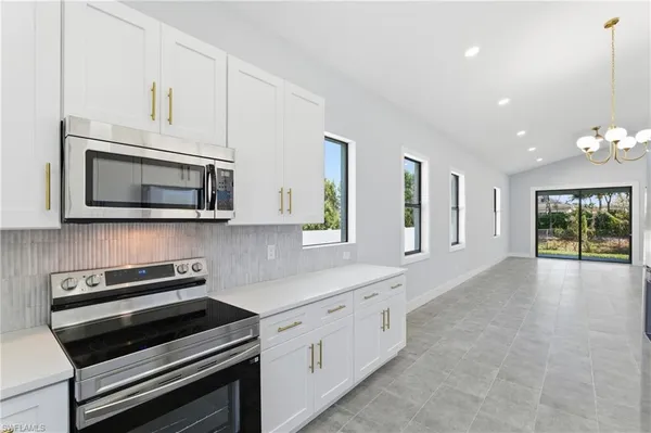 a kitchen with sink a microwave and cabinets