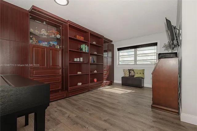 a view of an empty room with a fireplace and wooden floor