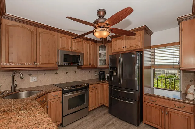 a kitchen with stainless steel appliances granite countertop a refrigerator a stove top oven a sink and dishwasher