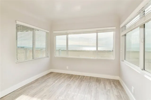 a view of a big room with wooden floor and a kitchen