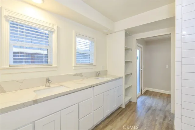 an empty room with wooden floor and ceiling fan