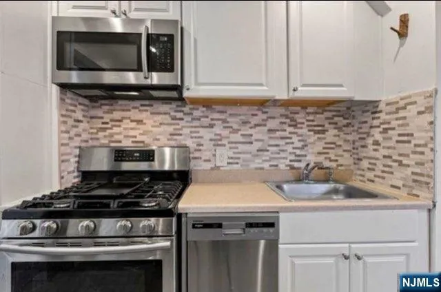 a kitchen with stove top oven and cabinets