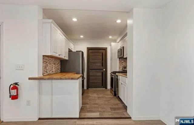 a kitchen with stainless steel appliances granite countertop a refrigerator and a stove