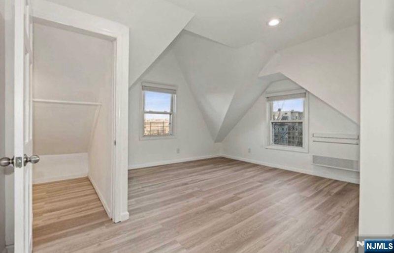 454 Undercliff Avenue Edgewater, NJ 07020 - Photo 14 of 18 an empty room with wooden floor closet and windows