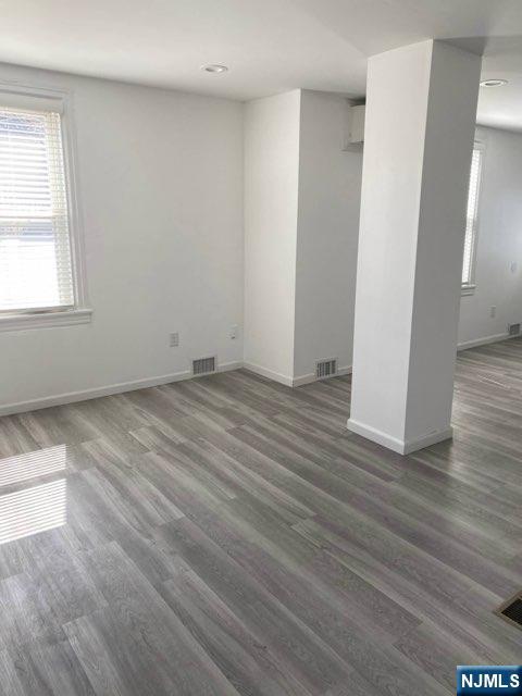 454 Undercliff Avenue Edgewater, NJ 07020 - Photo 4 of 18 an empty room with wooden floor and windows