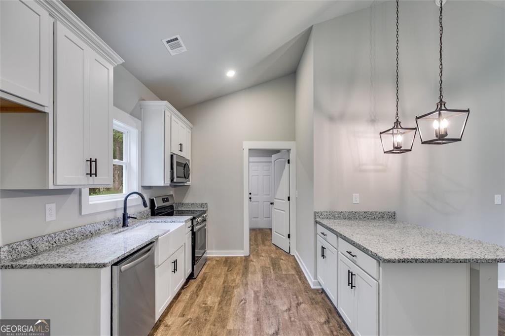 525 Grogan Road Buchanan, GA 30113 - Photo 21 of 40 a kitchen with granite countertop a sink stove and cabinets