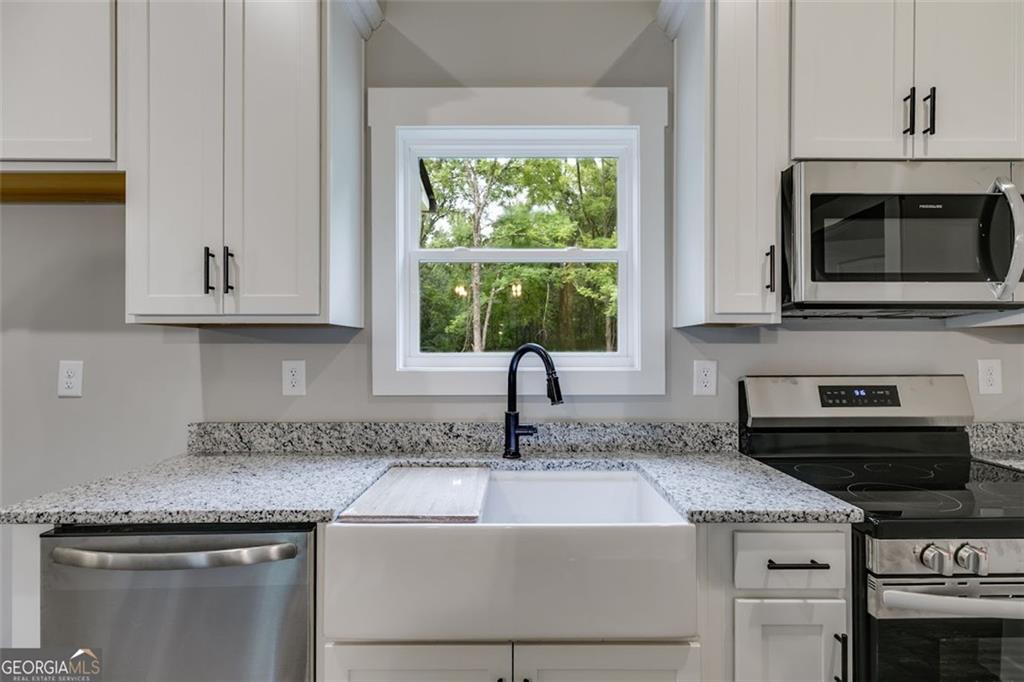 525 Grogan Road Buchanan, GA 30113 - Photo 22 of 40 a kitchen with granite countertop a sink and a stove