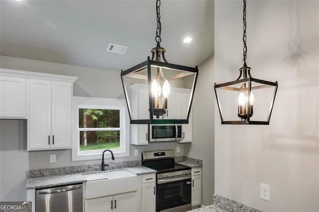 a kitchen with stainless steel appliances a stove sink and microwave