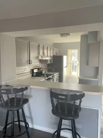 a kitchen with a dining table chairs and a refrigerator