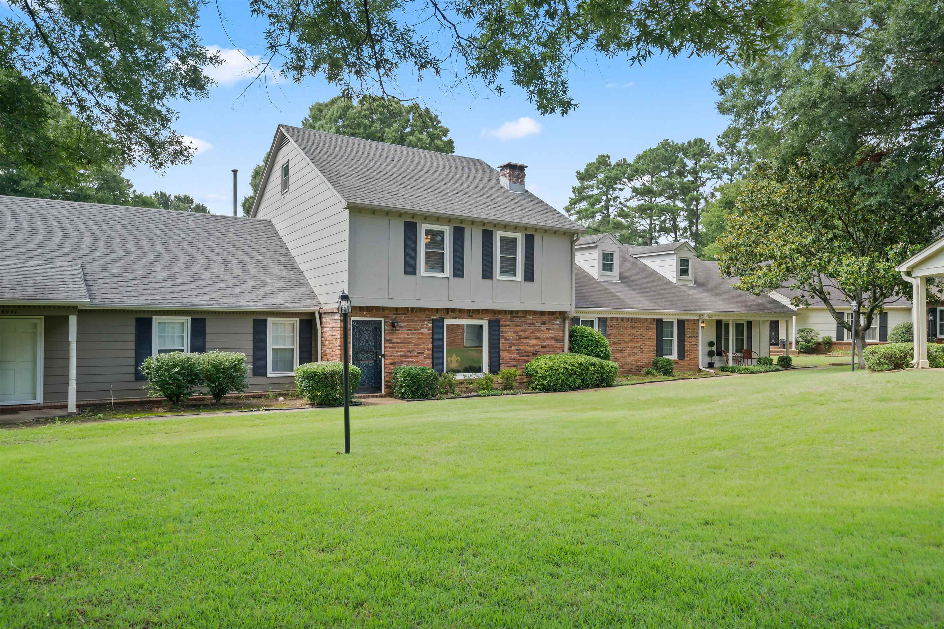 6943 Fords Station Road, Unit 64 Germantown, TN 38138 - Photo 3 of 30 Brick and siding exterior featuring dark shutters, a dark entry door, and a prominent chimney