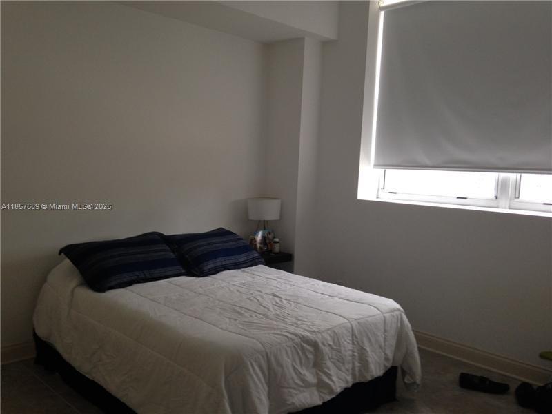 111 East Flagler Street, Unit 1007 Miami, FL 33131 - Photo 5 of 13 a bedroom with a bed and window