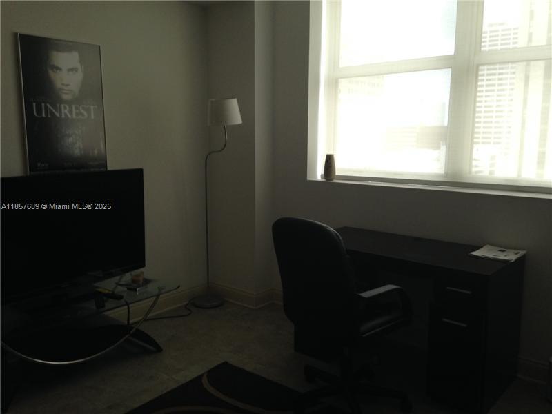 111 East Flagler Street, Unit 1007 Miami, FL 33131 - Photo 6 of 13 a room with a chair and a window
