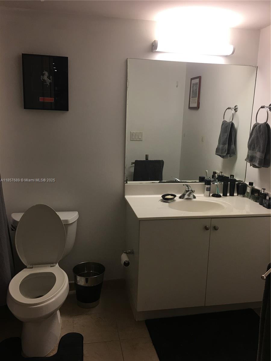 111 East Flagler Street, Unit 1007 Miami, FL 33131 - Photo 7 of 13 a bathroom with a toilet sink and mirror