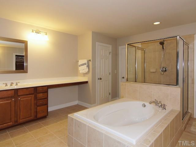 13002 Edsel Drive Raleigh, NC 27613 - Photo 17 of 24 Custom center pass-thru shower and garden tub with his-and-her vanities and three linen closets. Enormous walk-in/walk-thru closet. Master Bath/Spa