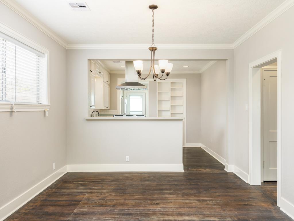 4528 Avenue R 1/2 Galveston, TX 77551 - Photo 16 of 22 a view of a room with wooden floor and chandelier