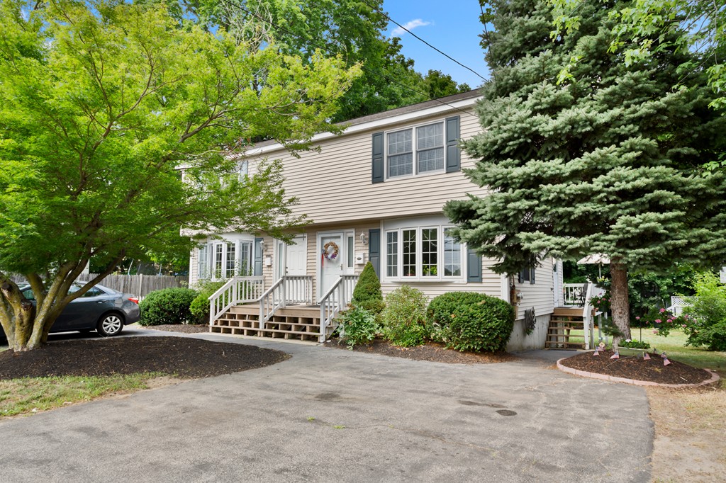 163 Mammoth Road, Unit 163 Lowell, MA 01854 - Photo 24 of 30 a front view of a house with a yard and garage