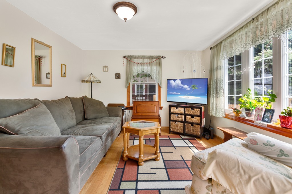 163 Mammoth Road, Unit 163 Lowell, MA 01854 - Photo 4 of 30 a living room with furniture a flat screen tv and a floor to ceiling window