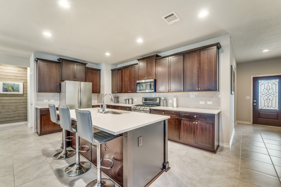 5921 Lehman Way Austin, TX 78747 - Photo 9 of 25 A contemporary kitchen features rich cabinetry, stainless appliances, and an inviting island with seating.