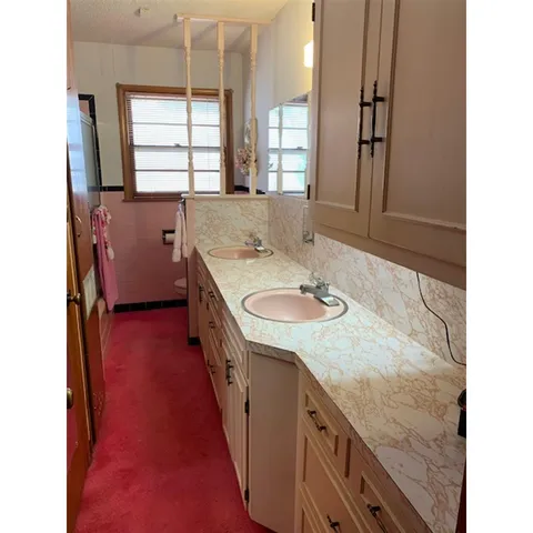 a bathroom with a granite countertop sink a mirror and a bathtub