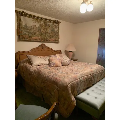 a bedroom with a bed and painting on the wall