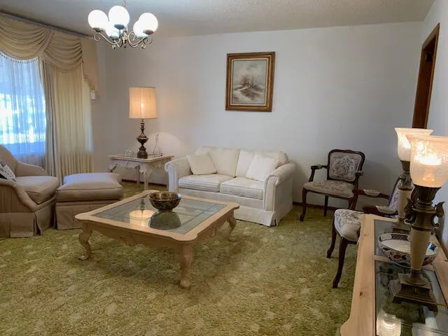 a living room with furniture a lamp and a chandelier