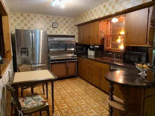 a kitchen with stainless steel appliances granite countertop a sink a stove and a refrigerator