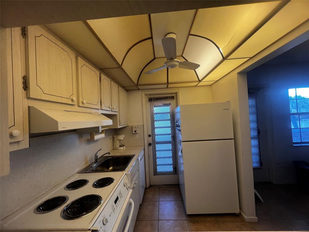 2050 Northeast 39th Street, Unit 209W Lighthouse Point, FL 33064 - Photo 11 of 27 a kitchen with a refrigerator and a stove