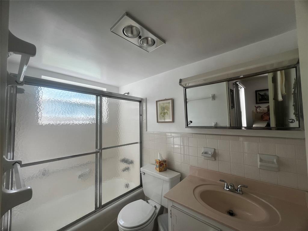 2050 Northeast 39th Street, Unit 209W Lighthouse Point, FL 33064 - Photo 13 of 27 a bathroom with a toilet sink a mirror and shower